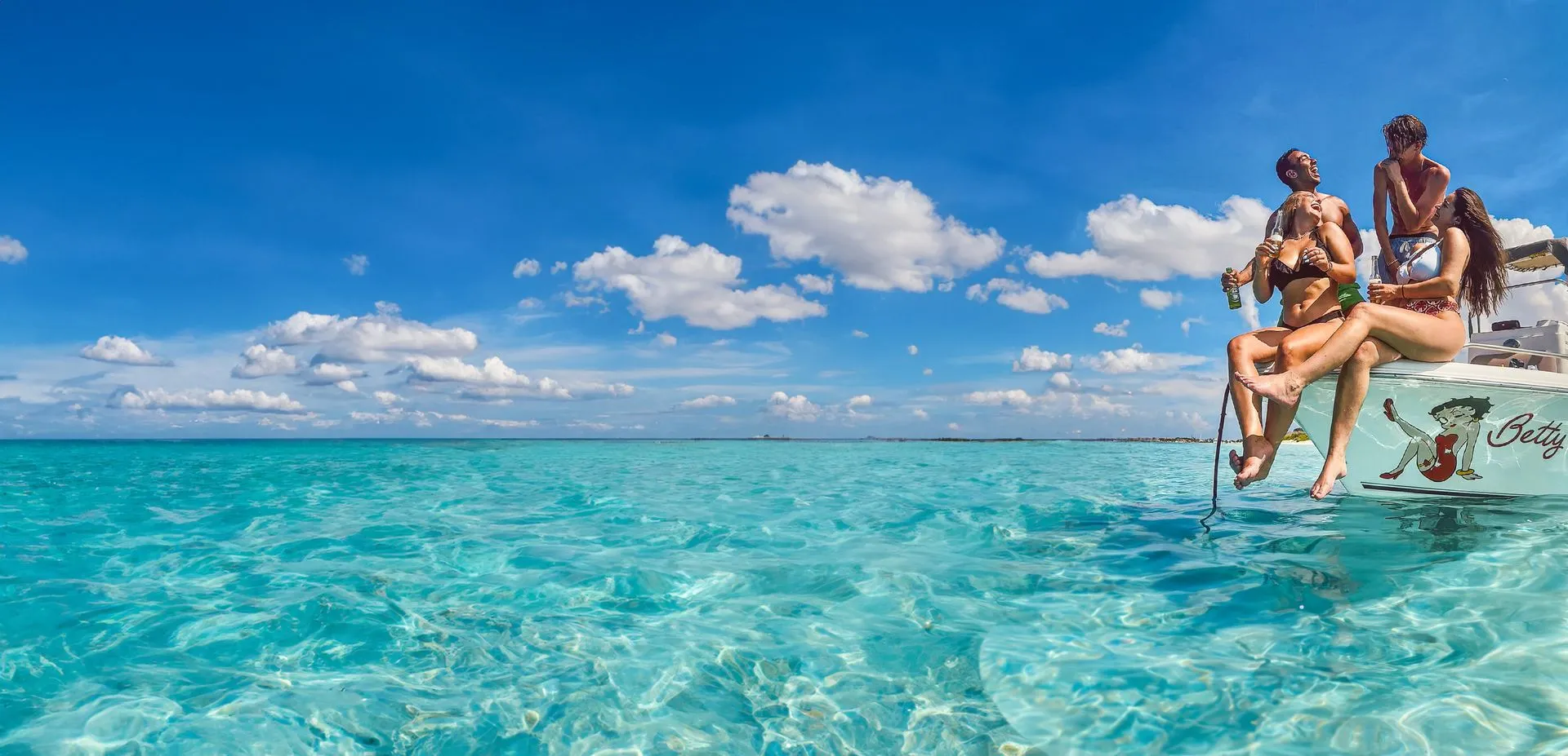 Gasten op de boeg van de Betty Boop in het turquoise water van Bonaire