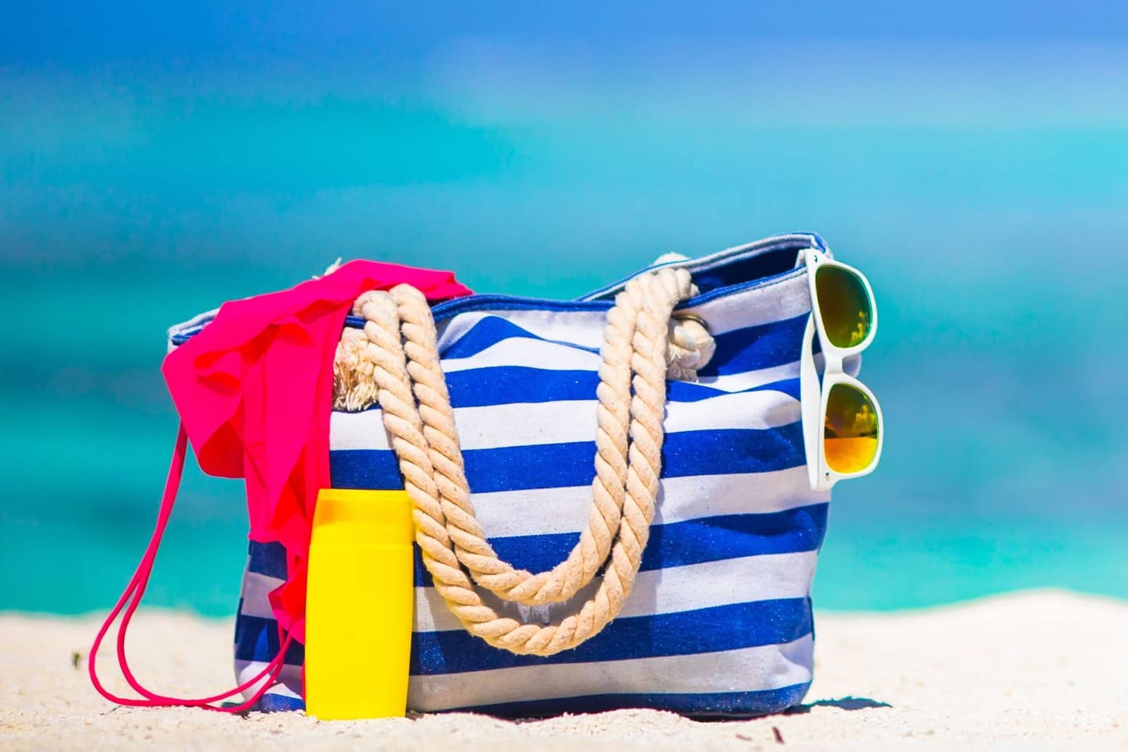 Strandtas met een zonnebril, zonnebrand spul en een bikini topje | Bootverhuur Bonaire